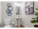 Powder room features a pedestal sink, decorative mirror and artwork, with neutral paint at 2759 Porches Ln, Dacula, GA 30019