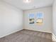 Bright bedroom featuring neutral carpet, two windows offering natural light, and fresh paint at 2759 Porches Ln, Dacula, GA 30019