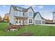 View of home's front lawn with landscaping and a three-car garage, grey and white siding and covered porch at 2759 Porches Ln, Dacula, GA 30019