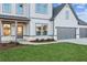 Home featuring a manicured lawn and a three-car garage, grey and white siding, and covered porch at 2759 Porches Ln, Dacula, GA 30019