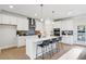 New kitchen with stainless appliances, white cabinets, large island with bar seating, and light wood flooring at 2759 Porches Ln, Dacula, GA 30019