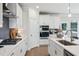 Modern kitchen with white cabinets, stainless steel appliances, grey backsplash and center island with sink at 2759 Porches Ln, Dacula, GA 30019
