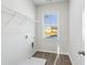 Clean laundry room with tile flooring, a storage rack, and a window for natural light at 2759 Porches Ln, Dacula, GA 30019