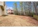 Wide backyard with lush green grass, trees, and a view of the back of the house at 5053 Kingsbridge Pass, Powder Springs, GA 30127