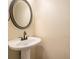 Powder room features a classic pedestal sink and framed circular mirror at 5053 Kingsbridge Pass, Powder Springs, GA 30127