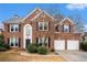 Charming two-story brick home with a well-manicured lawn and a two-car garage at 5053 Kingsbridge Pass, Powder Springs, GA 30127