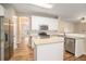 Kitchen features white cabinets, stainless appliances, tile backsplash, and center island at 5053 Kingsbridge Pass, Powder Springs, GA 30127