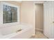 Spacious bathroom features a soaking tub with tile surround and a large window at 5053 Kingsbridge Pass, Powder Springs, GA 30127