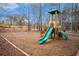 Community playground with slides and swings set amongst trees and pine straw at 5053 Kingsbridge Pass, Powder Springs, GA 30127