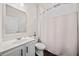 Clean bathroom featuring a shower with a white curtain, a sink with a large mirror, and wood floors at 614 Edgemore Rd, Canton, GA 30114
