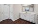 Bathroom vanity with white cabinets, wood-look floors and large framed mirror above sink at 614 Edgemore Rd, Canton, GA 30114