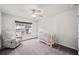 Cozy bedroom furnished with a crib and comfy armchair, bathed in natural light at 614 Edgemore Rd, Canton, GA 30114