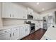 Modern kitchen showcasing white cabinets, stainless steel appliances, and dark hardwood floors at 614 Edgemore Rd, Canton, GA 30114