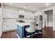 Well-lit kitchen featuring an island with seating, white cabinets, and stainless steel appliances at 614 Edgemore Rd, Canton, GA 30114