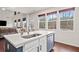 Bright kitchen featuring an island with a sink, stainless steel appliances, and large windows at 614 Edgemore Rd, Canton, GA 30114