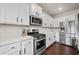 Contemporary kitchen with white cabinets, stainless steel appliances, and dark hardwood floors at 614 Edgemore Rd, Canton, GA 30114