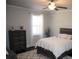 Comfortable bedroom with a ceiling fan, dark dresser, neutral walls, and plush white comforter at 5315 Austrian Pine Ct, Cumming, GA 30040