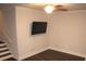 Cozy living room with dark wood floors, ceiling fan, and mounted television at 5315 Austrian Pine Ct, Cumming, GA 30040