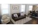 Comfortable living room featuring a leather sofa, accent chair, and view into dining room at 5315 Austrian Pine Ct, Cumming, GA 30040