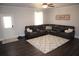 Spacious living room with dark wood floors and a comfortable leather sectional sofa at 5315 Austrian Pine Ct, Cumming, GA 30040