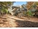 Rear view of home showcasing back porch with stairs, large backyard, and beautiful curb appeal at 4711 Oakleigh Manor Dr, Powder Springs, GA 30127