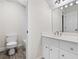 Bathroom featuring a toilet, white vanity with a modern sink, mirror, and tiled shower at 4711 Oakleigh Manor Dr, Powder Springs, GA 30127
