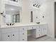 Bathroom featuring dual sinks, sleek black hardware, and modern light fixtures at 4711 Oakleigh Manor Dr, Powder Springs, GA 30127