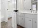 Bright bathroom featuring double sink vanity with white cabinetry and stylish wood-look tile flooring at 4711 Oakleigh Manor Dr, Powder Springs, GA 30127