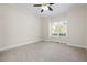 Bright, carpeted bedroom with ceiling fan and natural light from a large window at 4711 Oakleigh Manor Dr, Powder Springs, GA 30127