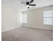 A well-lit bedroom with neutral walls, carpet, and a ceiling fan at 4711 Oakleigh Manor Dr, Powder Springs, GA 30127