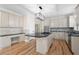 An open kitchen with hardwood floors, stainless appliances, and granite countertops and island with cooktop at 4711 Oakleigh Manor Dr, Powder Springs, GA 30127