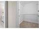 Walk-in closet with white wire shelving, tile floor, and attached bathroom at 4711 Oakleigh Manor Dr, Powder Springs, GA 30127