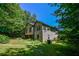 Side view of house and yard surrounded by trees and foliage at 5730 Paces Pl, Suwanee, GA 30024