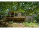 Rear view of home with a screened in deck and mature trees at 5730 Paces Pl, Suwanee, GA 30024