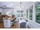 Open-concept kitchen with a dining area by large windows overlooking lush greenery at 5730 Paces Pl, Suwanee, GA 30024