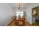 Bright dining room featuring wood floors, wainscoting, and an elegant modern chandelier at 5730 Paces Pl, Suwanee, GA 30024
