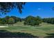 Scenic view of a lush green golf course with mature trees and blue sky at 5730 Paces Pl, Suwanee, GA 30024