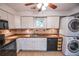 Kitchen featuring white cabinetry, modern appliances, and convenient laundry area at 5730 Paces Pl, Suwanee, GA 30024