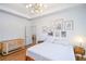 This main bedroom features a tray ceiling, modern light fixture and artwork above the headboard at 5730 Paces Pl, Suwanee, GA 30024