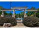 Inviting pool area with stone pillars, arched gate, and lush greenery creates a serene and stylish outdoor space at 5730 Paces Pl, Suwanee, GA 30024