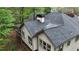 Back exterior featuring a well maintained roof, windows, and siding with lush trees around the perimeter at 5730 Paces Pl, Suwanee, GA 30024