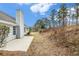 Home exterior featuring a chimney, patio, and wooded backyard at 619 Rivulett Ct, Lawrenceville, GA 30043