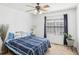 Bedroom features a ceiling fan, a large window, and a light blue comforter at 8740 Jenkins Rd, Winston, GA 30187