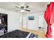 Bright bedroom featuring a ceiling fan, red curtains, and a flat screen TV at 8740 Jenkins Rd, Winston, GA 30187