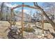 Backyard outdoor lounge area featuring rustic pergola bench swing and firepit at 8740 Jenkins Rd, Winston, GA 30187