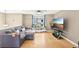 Living room features a comfortable sectional sofa, large windows, hardwood flooring, and a ceiling fan at 8740 Jenkins Rd, Winston, GA 30187