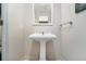 Powder room featuring pedestal sink, neutral color palette and a bright inset mirror reflecting the space at 195 14Th Ne St # Ts8, Atlanta, GA 30309