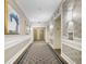 Hallway view featuring a patterned carpet, wainscoting, artwork and elevator access at 195 14Th Ne St # Ts8, Atlanta, GA 30309