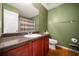 Cozy bathroom with a granite-look counter, wood cabinets, and a shower-tub combo at 2322 Coach Way, Jonesboro, GA 30236
