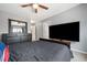 A modern primary bedroom with ceiling fan, carpet, large dresser, and a large television at 2322 Coach Way, Jonesboro, GA 30236
